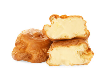 Cut and whole delicious profiteroles with cream filling on white background