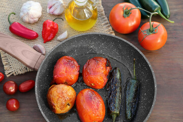 Frying pan and ingredients for salsa sauce on wooden table, flat lay