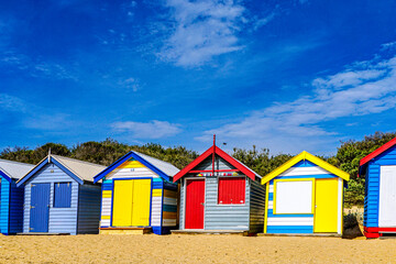 Fototapeta na wymiar Colored beach huts or beach cabins in Melbourne Beach. They are a small, usually wooden and often brightly colored, box above the high tide mark on popular bathing beaches. Australia, 2017