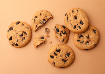 Delicious chocolate chip cookies on beige background, flat lay