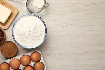Flat lay composition with flour and different ingredients on white wooden table, space for text. Yeast pastry