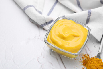 Tasty curry sauce and powder on white textured table. Space for text