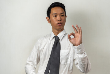 Asian businessman making a gesture of joy holding up OK sign