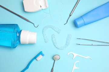 Transparent plastic dental aligners and care products on a colored background