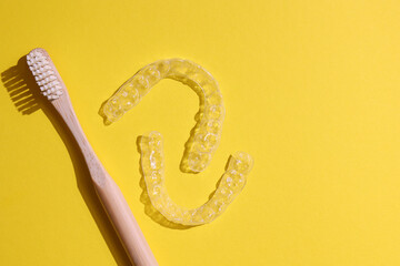Transparent plastic dental aligners on a colored background