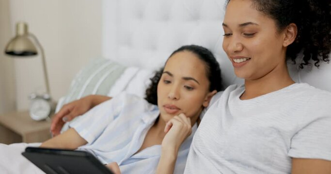 Couple of friends, relax and bed on tablet streaming service, website or online application in lgbtq love at home. Planning, typing and happy lesbian women or people on digital technology in bedroom