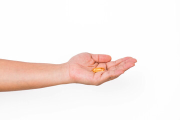 Hand holding a capsule or pill isolated on white background.
