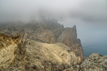 Dead city in fog and clouds. Khoba-Tele Ridge of Karadag Reserve in spring. Crimea