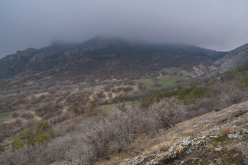Landscape of Karadag Reserve in spring. View of mountains in fog and clouds. Crimea