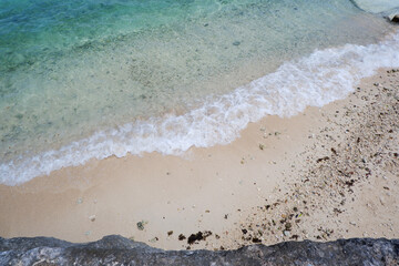 Blue ocean wave. White sand beach with blue water and wave. Tropical sea background.