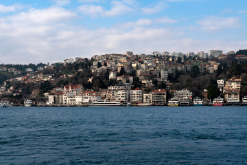 Fototapeta na wymiar View of the Arnavutkey district of Istanbul on the European part of the city behind the Bosphorus Bridge from the water area of the Bosphorus on a sunny day, Istanbul, Turkey