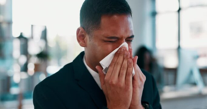 Sick, desk and man blowing nose with tissue at work, ill and overworked from flu or cold. Allergies, virus and office employee health risk from illness, burnout or businessman with sinus problem.