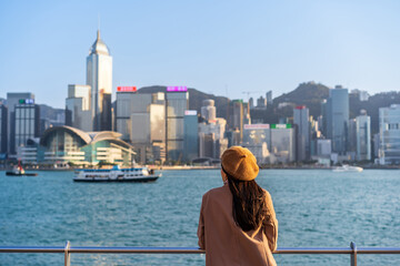 Young woman traveler relaxing and enjoying the sunset atmosphere at Victoria harbour in Hong Kong