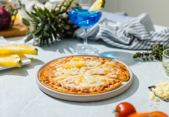 Top view shot of triangle shape piece of delicious tasty Hawaiian traditional Italian crust thin crispy ham and pineapple pizza stretching cheese up from table.