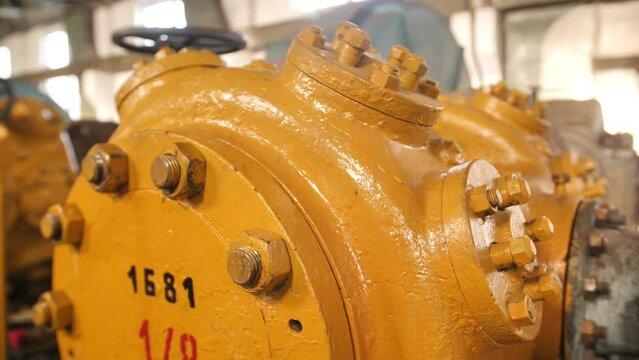 Industrial installation in the workshop close-up. Equipment at the gas-to-liquid processing plant. The catalyst plant. Yellow mechanisms of metal devices at the old manufactory. Ammonia processing.