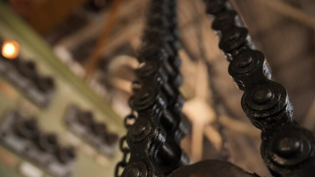 Huge greasy roller chain in motion. A crawler chain covered with machine oil. Conveyor belt in work.