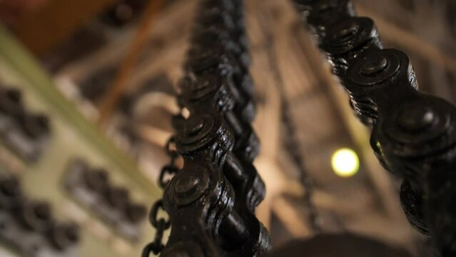 Huge greasy roller chain in motion. A crawler chain covered with machine oil. Conveyor belt in work.