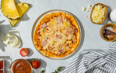 Top view shot of triangle shape piece of delicious tasty Hawaiian traditional Italian crust thin crispy ham and pineapple pizza stretching cheese up from table.