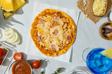 Top view shot of triangle shape piece of delicious tasty Hawaiian traditional Italian crust thin crispy ham and pineapple pizza stretching cheese up from table.