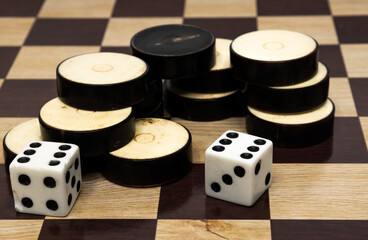 Checkers and dice on a board background,. Board games. Copy space.