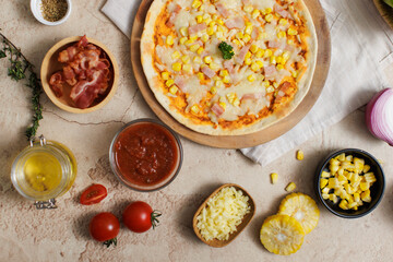Top view shot of delicious tasty juicy cheesy corn and ham Italian pizza placed on wooden board on...