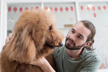 Young man hugs his pet dog with happy and smiling at home. Young male playing having fun with cute dog. Lovely pet