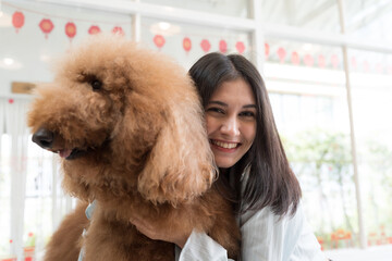 Young woman hugs her pet dog with happy and smiling at home. Young female playing having fun with cute dog. Lovely pet