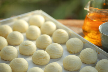 Toasted Mung Bean Cake form the oven.Chinese pastry or moon cake filled with mung bean paste and salted egg yolk in hot plate. Selective focus and free copy space.