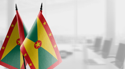 Small flags of the Grenada on an abstract blurry background
