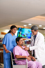 Fototapeta premium Indian male doctor checkup to patient with stethoscope on wheel chair.