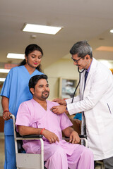 Fototapeta premium Indian male doctor checkup to patient with stethoscope on wheel chair.