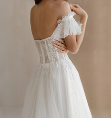 Gorgeous long wedding backless dress decorated with floral lace. Bride in the shoulderless white...