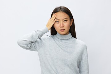 Asian woman holding her hand to her head for severe headache, migraine white background