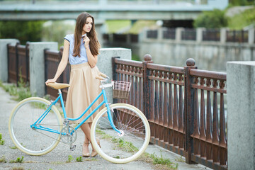 Smiling Hipster Girl and Bike in the City and Copy Space. Urban Youth Lifestyle Concept.