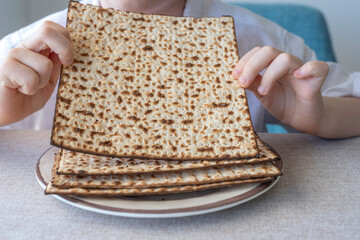 Matzah for Jewish holiday Pesach (Passover) in the hands of a child.