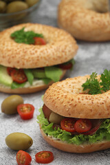 Sesame bagels with tomatoes, ham and olives	