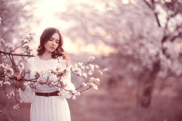 Fototapeta na wymiar happy girl dreaming in a blooming garden, fresh tenderness spring woman in flowers