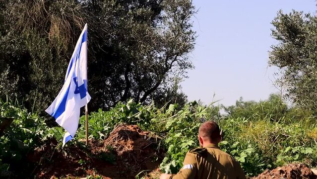 Israeli soldier runs up to the waving Israel Flag puts on an IDF army beret and salutes the main symbol of Israel. Video concept: IDF, Israeli Memorial Day, soldiers Israel