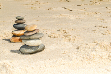 Fototapeta na wymiar flat pebbles laid on the sandy beach sea coast