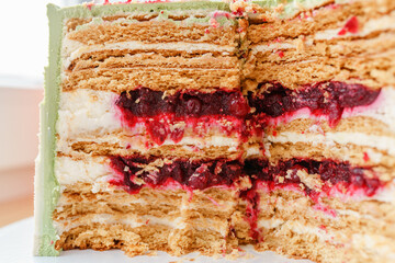A close-up cut of a cake with cakes and a berry layer
