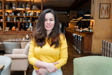 Young woman with long hair in a beautiful restaurant with lamps and chairs