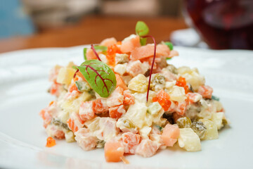 Olivier salad with salmon on a white plate