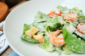 Fototapeta na wymiar Caesar salad with shrimp on a white plate
