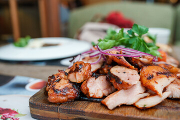 A plate with barbecue shish kebab of different types of meat and red onion rings
