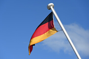Deutschlandflagge an einem Bootsmast vor blauem Himmel