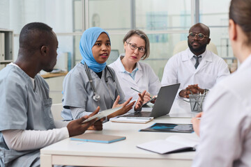 Group of colleagues discussing difficult operation together during a meeting in office