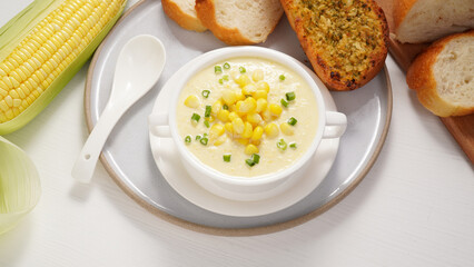 Corn Soup and Bread breakfast menu on white table