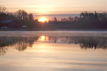 Beautiful scenery of wooden pier by misty lake in morning light. Otomin Lake, Kashubia, Poland