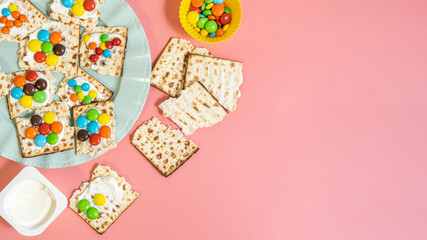 Pieces of matzah, cream cheese, colorful candies for making tasty breakfast for kids during Jewish...