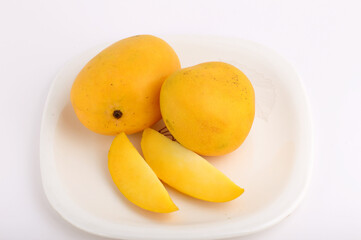 Mango fruit in basket with slice on white background